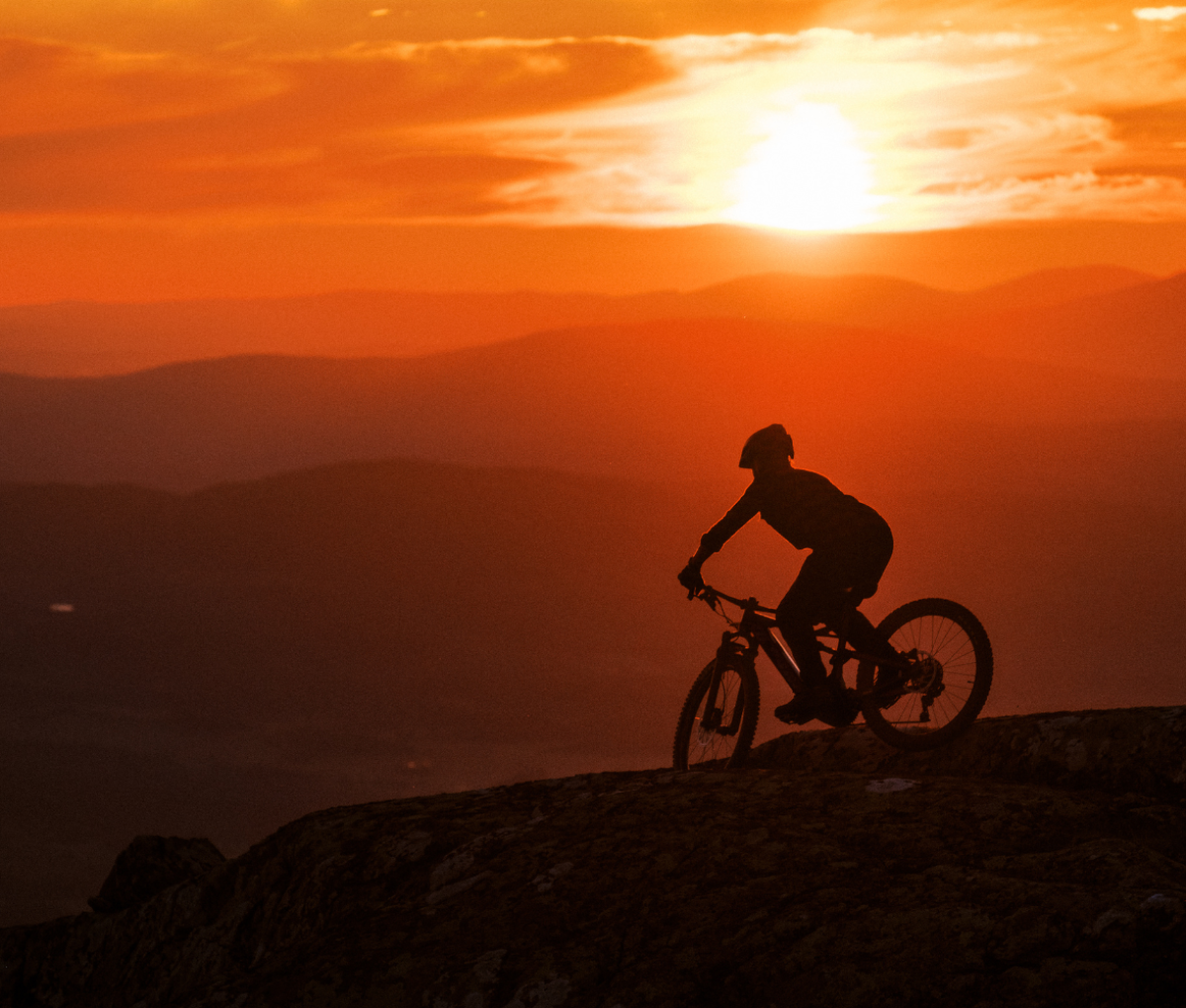 a person bikes along a mountain-side in Jämtland Härjedalen at sunset.