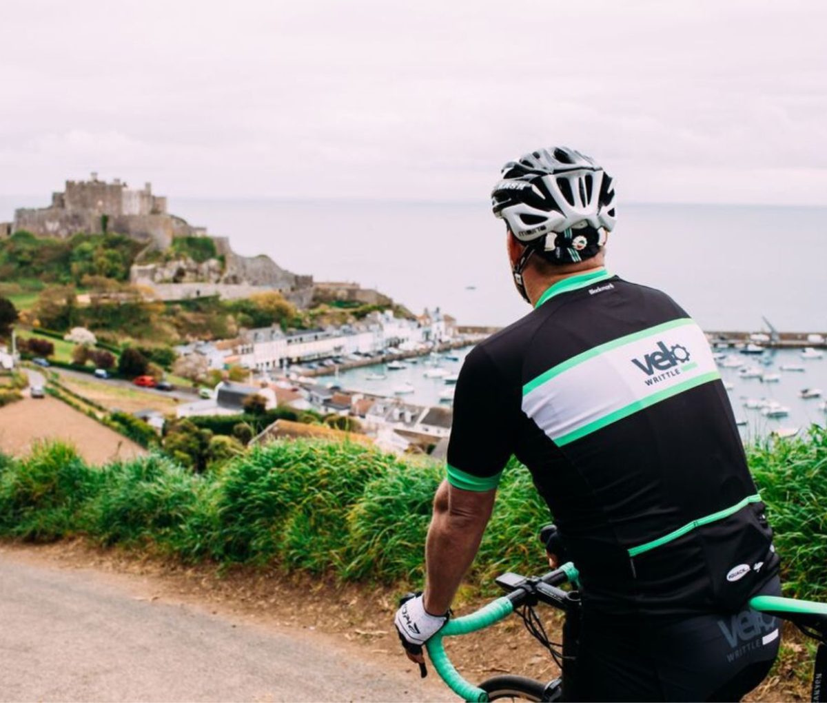 A cyclist looking over Gorey Harbour, Jersey